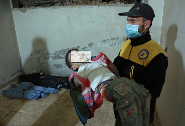 EDITORS NOTE: Graphic content / A Syrian medic holds the body of a child at a makeshift clinic following a suspected chemical attack on the rebel-held village of al-Shifuniyah in the Eastern Ghouta region on the outskirts of the capital Damascus late on February 25, 2018. A child died and at least 13 other people suffered breathing difficulties after a suspected chemical attack on the besieged Syrian rebel enclave, a medic and a monitor said. The Britain-based Syrian Observatory for Human Rights said 14 civilians had suffered breathing difficulties after a regime warplane struck the village.   / AFP PHOTO / HAMZA AL-AJWEH