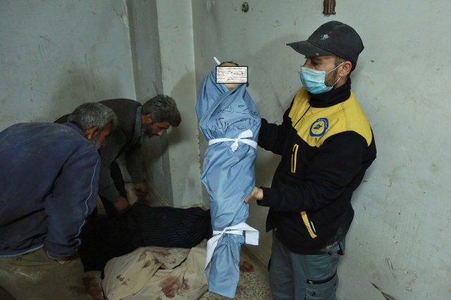 EDITORS NOTE: Graphic content / A Syrian medic displays the body of a child at a makeshift clinic following a suspected chemical attack on the rebel-held village of al-Shifuniyah in the Eastern Ghouta region on the outskirts of the capital Damascus late on February 25, 2018. A child died and at least 13 other people suffered breathing difficulties after a suspected chemical attack on the besieged Syrian rebel enclave, a medic and a monitor said. The Britain-based Syrian Observatory for Human Rights said 14 civilians had suffered breathing difficulties after a regime warplane struck the village.   / AFP PHOTO / HAMZA AL-AJWEH