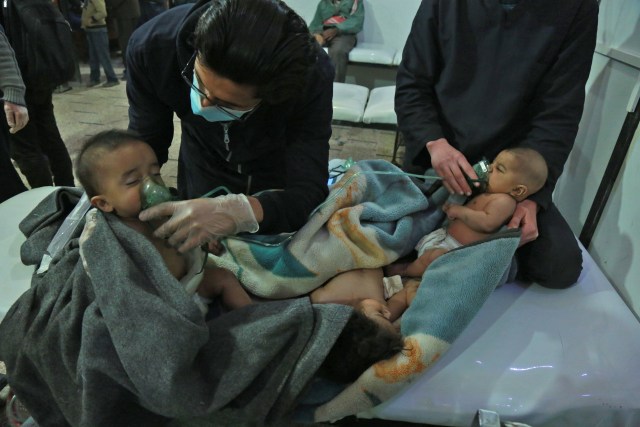 Syrian babies receive treatment for a suspected chemical attack at a makeshift clinic on the rebel-held village of al-Shifuniyah in the Eastern Ghouta region on the outskirts of the capital Damascus late on February 25, 2018.   A child died and at least 13 other people suffered breathing difficulties after a suspected chemical attack on the besieged Syrian rebel enclave, a medic and a monitor said. The Britain-based Syrian Observatory for Human Rights said 14 civilians had suffered breathing difficulties after a regime warplane struck the village.   / AFP PHOTO / HAMZA AL-AJWEH