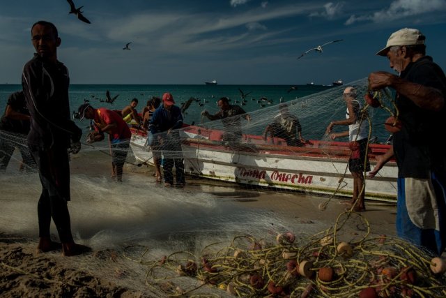 Pescadores con la pesca del día Credit Meridith Kohut para The New York Times