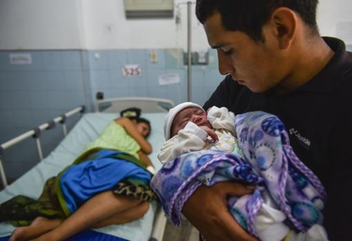 El venezolano José Luis González, con su hijo recién nacido en el hospital de Cúcuta-Afp