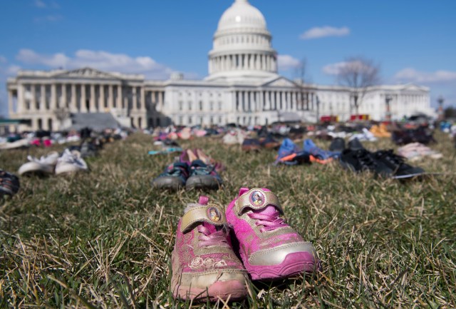 The lawn outside the US Capitol is covered with 7,000 pairs of empty shoes to memorialize the 7,000 children killed by gun violence since the Sandy Hook school shooting, in a display organized by the global advocacy group Avaaz, in Washington, DC, March 13, 2018. / AFP PHOTO / SAUL LOEB