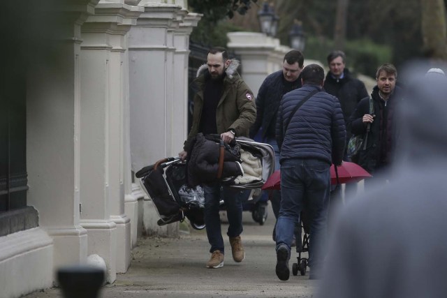 People arrive carrying luggage at the Russian Embassy in London on March 20, 2018 some of whom are seen leaving again to board a van bearing diplomatic plates. Dozens of people including adults with children arrived at the Russian embassy on March 20 morning and then left carrying luggage in vehicles bearing diplomactic registration plates. Britain last week announced the expulsion of 23 Russian diplomats over the spy poisoning row, prompting a tit-for-tat response from Moscow. / AFP PHOTO / Daniel LEAL-OLIVAS