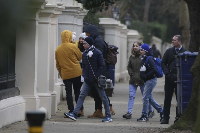 People arrive carrying luggage at the Russian Embassy in London on March 20, 2018 some of whom are seen leaving again to board a van bearing diplomatic plates. Dozens of people including adults with children arrived at the Russian embassy on March 20 morning and then left carrying luggage in vehicles bearing diplomactic registration plates. Britain last week announced the expulsion of 23 Russian diplomats over the spy poisoning row, prompting a tit-for-tat response from Moscow. / AFP PHOTO / Daniel LEAL-OLIVAS