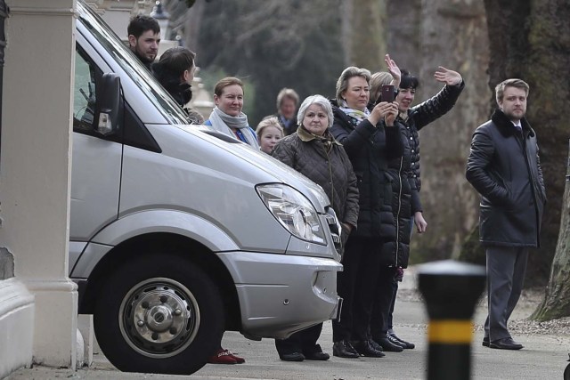 People wave-off others that left the Russian Embassy in London on March 20, 2018 carrying luggage and boarded a van bearing diplomatic plates. Dozens of people including adults with children arrived at the Russian embassy on March 20 morning and then left carrying luggage in vehicles bearing diplomactic registration plates. Britain last week announced the expulsion of 23 Russian diplomats over the spy poisoning row, prompting a tit-for-tat response from Moscow. / AFP PHOTO / Daniel LEAL-OLIVAS
