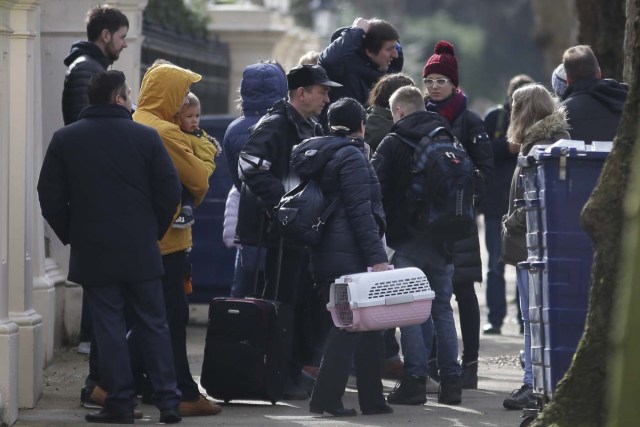 People carrying luggage leave the Russian Embassy in London on March 20, 2018 and board a van bearing diplomatic plates. Dozens of people including adults with children arrived at the Russian embassy on March 20 morning and then left carrying luggage in vehicles bearing diplomactic registration plates. Britain last week announced the expulsion of 23 Russian diplomats over the spy poisoning row, prompting a tit-for-tat response from Moscow. / AFP PHOTO / Daniel LEAL-OLIVAS