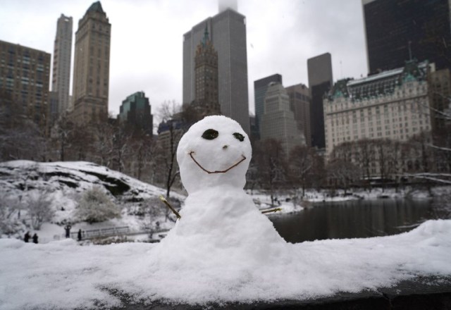 A snowman on the Gapstow Bridge in Central Park in New York  March 21, 2018 as the fourth nor'easter in a month hits the tri-state area on the first full day of spring. Winter Storm Toby, is throwing a fresh blanket of snow just as spring begins. The storm caused heavy damaged in the south with hail, high winds and tornadoes. / AFP PHOTO / TIMOTHY A. CLARY