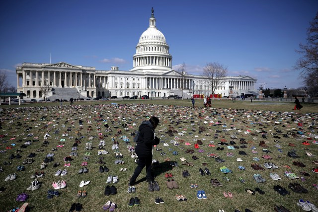 WASHINGTON, DC - MARCH 13: Seven thousand pairs of shoes, representing the children killed by gun violence since the mass shooting at Sandy Hook Elementary School in 2012, are spread out on the lawn on the east side of the U.S. Capitol March 13, 2018 in Washington, DC. Organized by the online activist group Avaaz, the shoes are intended to urge Congress to pass gun-reform legislation. Chip Somodevilla/Getty Images/AFP
