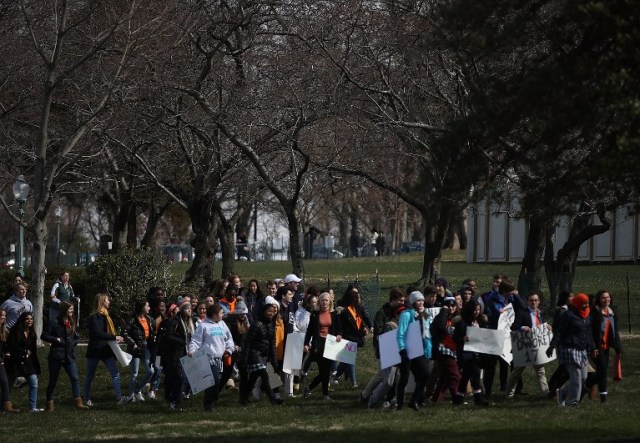 WASHINGTON, DC - MARCH 14: Students from the Washington area carry signs as they march to the U.S. Capitol to urge Congress to take action against gun violence on March 14, 2018 on Capitol Hill in Washington, DC. It was one month ago today that a gunman killed 17 people at Marjory Stoneman Douglas High School in Parkland, Florida. Mark Wilson/Getty Images/AFP
