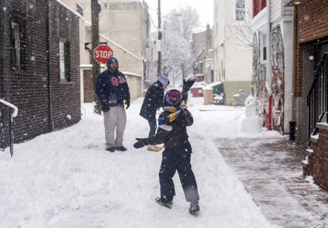 PHILADELPHIA, PA - MARCH 21: Kenny Racowski, 7, right, launches a snowball at his parents on March 21, 2018 in Philadelphia, Pennsylvania. The fourth nor'easter in three weeks has forced school closures and flight cancellations on the second day of spring.   Jessica Kourkounis/Getty Images/AFP