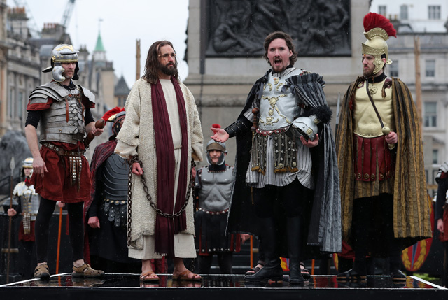 Actor Oliver Thorn (2R), plays the role of Pontius Pilate, as Actor James Burke-Dunsmore (2L) plays the role of Jesus Christ, during a performance of Wintershall's 'The Passion of Jesus' on Good Friday in Trafalgar Square in London on March 30, 2018.  The Passion of Jesus tells the story from the Bible of Jesus's visit to Jerusalem and his crucifixion. On Good Friday 20,000 people gather to watch the Easter story in central London. One hundred Wintershall players bring their portrayal of the final days of Jesus to this iconic location in the capital. / AFP PHOTO / Daniel LEAL-OLIVAS