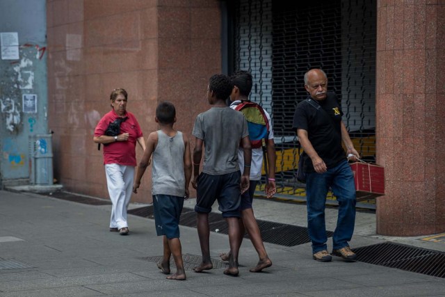 Fotografía del 3 de marzo de 2018 de niños caminando en un calle de Caracas (Venezuela). La inédita crisis económica y social de Venezuela se hace inocultable en calles y casas de abrigo que a diario reciben a niños que han quedado desamparados después de que sus padres emigraran a otro país a buscar nuevas formas de ingresos y los dejaran a cargo de personas que no pueden mantenerlos. EFE/MIGUEL GUTIÉRREZ