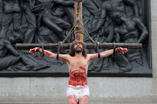Actor James Burke-Dunsmore plays the role of Jesus Christ, nailed to a cross, during a performance of Wintershall's 'The Passion of Jesus' on Good Friday in Trafalgar Square in London on March 30, 2018.  The Passion of Jesus tells the story from the Bible of Jesus's visit to Jerusalem and his crucifixion. On Good Friday 20,000 people gather to watch the Easter story in central London. One hundred Wintershall players bring their portrayal of the final days of Jesus to this iconic location in the capital. / AFP PHOTO / Daniel LEAL-OLIVAS