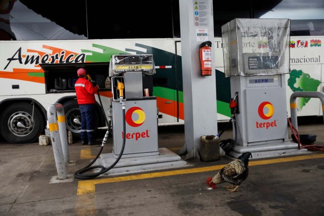 A gas station worker pumps fuel into a Rutas de America bus as a chicken looks for food, near Pamplona, Colombia, November 8, 2017. Carlos Garcia Rawlins: "We stopped to refuel the bus and although the passengers did not get off except those who urgently needed to use the restrooms, I had agreed with the driver that I would get off at every opportunity to take pictures. This time, there was a chicken pecking at the gas station floor in search of food and creating a peculiar scene, almost something out of the Latin American magic realism". REUTERS/Carlos Garcia Rawlins SEARCH "RAWLINS BUS" FOR THIS STORY. SEARCH "WIDER IMAGE" FOR ALL STORIES.