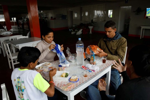 Alejandra Rodriguez (R) talks to her sister Natacha Rodriguez (2nd L), while she, her son David Vargas (L) and Adrian Naveda, have a meal with the food they brought from Caracas route to Chile, at a restaurant in Supe Puerto, Peru, November 12, 2017. Most of the migrants were very short of money and unsure how much they would need to settle in their new homes, so they tried to save as much as possible. At rest stops some could afford to buy hot food but others had to continue eating the sandwiches and canned food they brought from Caracas. REUTERS/Carlos Garcia Rawlins SEARCH "RAWLINS BUS" FOR THIS STORY. SEARCH "WIDER IMAGE" FOR ALL STORIES.