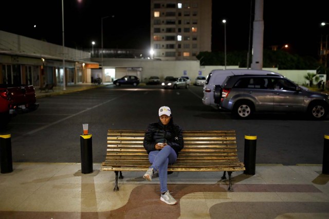 Alejandra Rodriguez, who travelled by bus from Venezuela to Chile, uses her cellphone to speak with her boyfriend who lives in Venezuela, as she sits at a bench of a shopping mall near her house to take advantage of a free internet connection in Concon, Chile, November 20, 2017. Alejandra walked several blocks during the night to a shopping mall and sat for hours in front of the closed stores, to use the free internet network and chat with her loved ones in Venezuela. REUTERS/Carlos Garcia Rawlins SEARCH "RAWLINS BUS" FOR THIS STORY. SEARCH "WIDER IMAGE" FOR ALL STORIES.