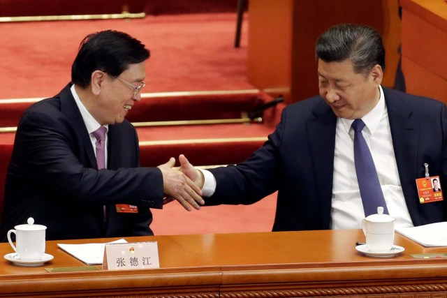 Chinese President Xi Jinping shakes hands with Chairman of the Standing Committee of the National People's Congress (NPC) Zhang Dejiang after a vote on a constitutional amendment lifting presidential term limits, during third plenary session of the National People's Congress (NPC) at the Great Hall of the People in Beijing, China March 11, 2018. REUTERS/Jason Lee
