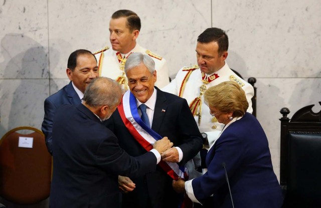 Chile's newly sworn in President Sebastian Pinera receives the sash from President of the Senate Carlos Montes, next to former president Michelle Bachelet, at the Congress in Valparaiso, Chile March 11, 2018. REUTERS/ Ivan Alvarado