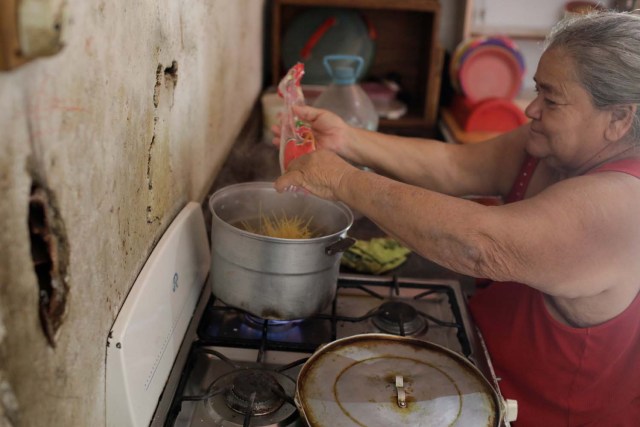 Antonia Torres, madre de Yuni Pérez, cocina para siete personas un paquete de pasta recibido en una caja de CLAP, una donación del gobierno venezolano de alimentos básicos, en su casa en el barrio pobre de Petare en Caracas, Venezuela el 9 de marzo de 2018. Fotografía tomada 9 de marzo de 2018. REUTERS / Marco Bello