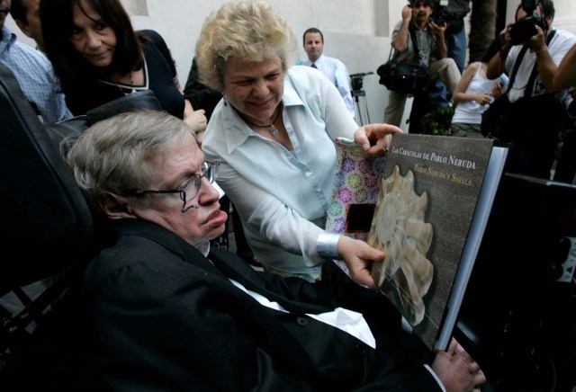 FILE PHOTO: British physicist Stephen Hawking looks at a book of Chile's Nobel Laureate Pablo Neruda after a meeting with Chile's President Michelle Bachelet (unseen) at the Presidential Palace in Santiago January 17, 2008. REUTERS/Victor Ruiz Caballero/File Photo
