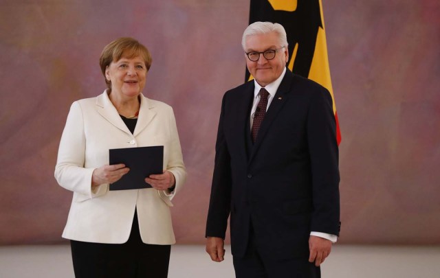 German Chancellor Angela Merkel receives her certificate of appointment from President Frank-Walter Steinmeier after being re-elected as chancellor, during a ceremony at Bellevue Palace in Berlin, Germany, March 14, 2018. REUTERS/Fabrizio Bensch