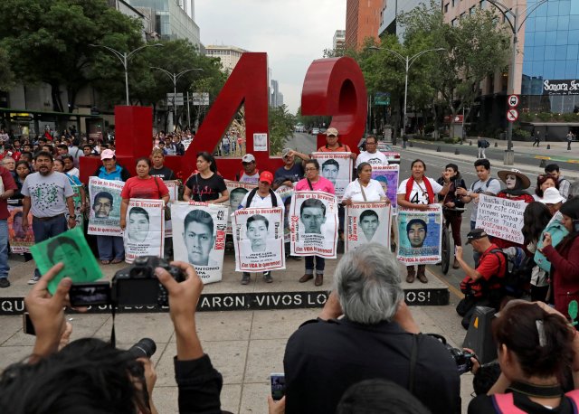 Los familiares posan con imágenes de algunos de los 43 estudiantes del desaparecido Colegio Ayotzinapa Raúl Isidro Burgos frente a un monumento del número 43, durante una marcha para conmemorar el 41º mes desde su desaparición en el estado de Guerrero, en la Ciudad de México, México 26 de febrero , 2018. REUTERS / Henry Romero - RC1C78D101F0 / Foto del archivo
