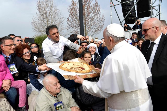 Faithful present pizza to Pope Francis during his pastoral visit in Pietrelcina, Italy March 17, 2018. Osservatore Romano/Handout via REUTERS ATTENTION EDITORS - THIS IMAGE WAS PROVIDED BY A THIRD PARTY