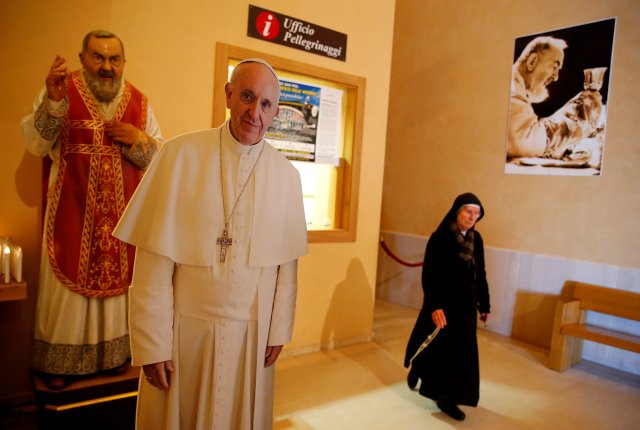 A nun walks past a figure depicting Saint Pio of Pietrelcina (Padre Pio) and Pope Francis in San Giovanni Rotondo, Italy, March 17, 2018. REUTERS/Tony Gentile