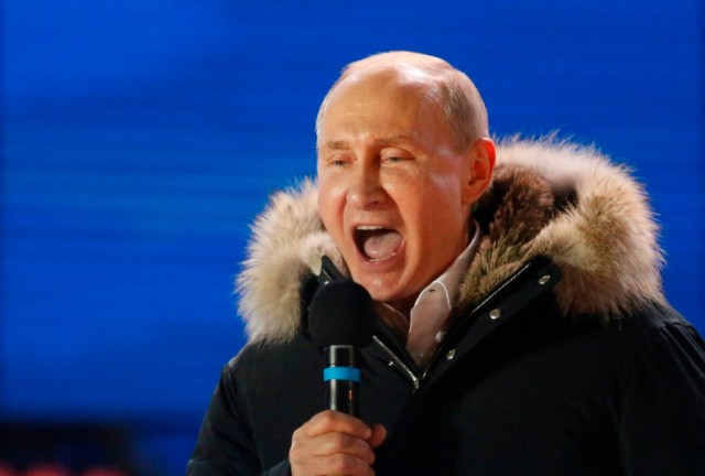 Russian President and Presidential candidate Vladimir Putin delivers a speech during a rally and concert marking the fourth anniversary of Russia's annexation of the Crimea region, at Manezhnaya Square in central Moscow, Russia March 18, 2018. REUTERS/Gleb Garanich