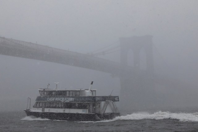 An East River Ferry boat makes its way under the Brooklyn Bridge during a nor'easter in New York, U.S., March 21, 2018. REUTERS/Shannon Stapleton TPX IMAGES OF THE DAY