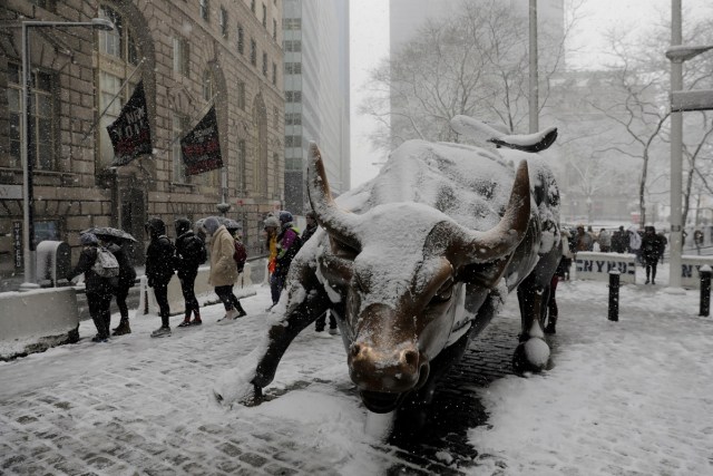 Pedestrians walk past a snow covered bull sculpture during a late season nor'easter in New York, U.S., March 21, 2018. REUTERS/Lucas Jackson TPX IMAGES OF THE DAY