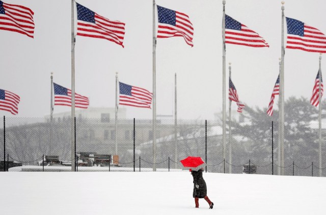 A woman holds an umbrella as she walks toward the Washington Monument during a snowstorm in Washington, U.S., March 21, 2018. REUTERS/Kevin Lamarque TPX IMAGES OF THE DAY
