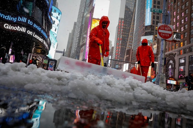 Workers clear snow during a winter nor'easter storm in Times Square in New York City, U.S., March 21, 2018. REUTERS/Brendan McDermid TPX IMAGES OF THE DAY