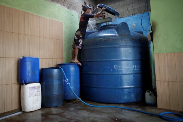 Roberto Souza inspecciona un depósito con agua utilizada para lavar automóviles, el día del racionamiento de agua, en el barrio de Ceilandia en Brasilia, Brasil, el 21 de marzo de 2018. Fotografía tomada el 21 de marzo de 2018. REUTERS / Ueslei Marcelino