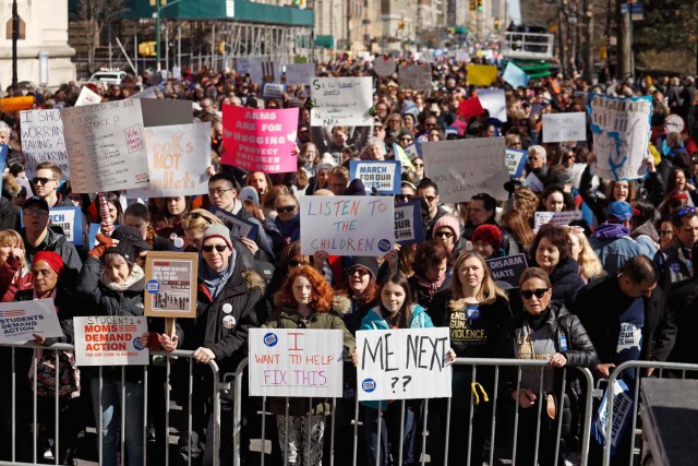 Protesters raise signs during a "March For Our Lives" demonstration demanding gun control in New York City, U.S. March 24, 2018. REUTERS/Shannon Stapleton