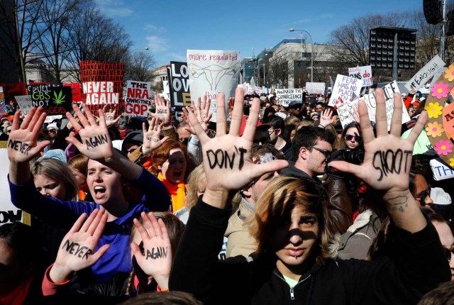 Participants carry signs and show slogans on their hands as students and gun control advocates hold the "March for Our Lives" event demanding gun control after recent school shootings at a rally in Washington, U.S., March 24, 2018. REUTERS/Aaron P. Bernstein
