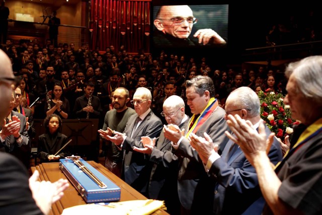 Mourners and members of the National System of Children and Youth Orchestras applaud next to the coffin of its founder Jose Antonio Abreu during his memorial service in Caracas, Venezuela March 25, 2018. REUTERS/Marco Bello