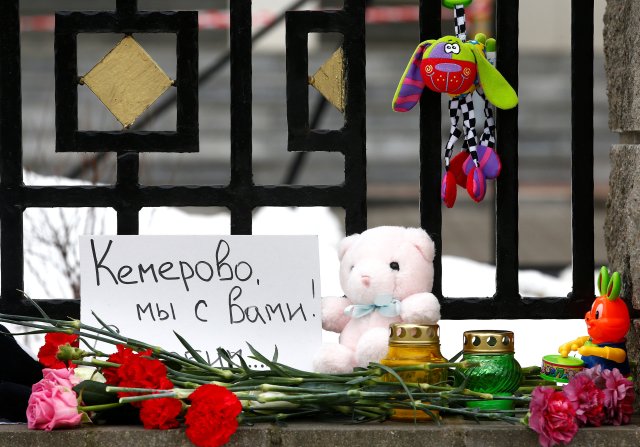 Juguetes y flores colocados para conmemorar a las víctimas del incendio del centro comercial en Kemerovo son vistos en la embajada rusa en Minsk, Bielorrusia el 27 de marzo de 2018. El letrero dice: "Kemerovo, estamos con usted. Estamos de luto". REUTERS / Vasily Fedosenko