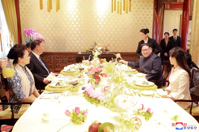 REFILE - ADDING CITY North Korean leader Kim Jong Un and wife Ri Sol Ju, and Chinese President Xi Jinping and wife Peng Liyuan meet, as Kim Jong Un paid an unofficial visit to Beijing, China, in this undated photo released by North Korea's Korean Central News Agency (KCNA) in Pyongyang March 28, 2018. KCNA/via Reuters ATTENTION EDITORS - THIS IMAGE WAS PROVIDED BY A THIRD PARTY. REUTERS IS UNABLE TO INDEPENDENTLY VERIFY THIS IMAGE. NO THIRD PARTY SALES. NOT FOR USE BY REUTERS THIRD PARTY DISTRIBUTORS. SOUTH KOREA OUT. NO COMMERCIAL OR EDITORIAL SALES IN SOUTH KOREA.