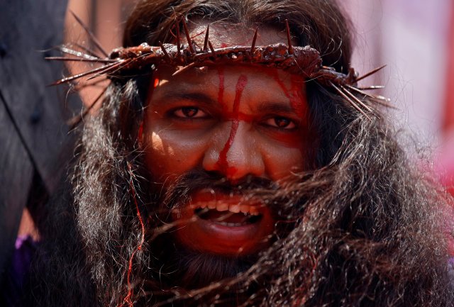A man portraying Jesus Christ carries a cross while performing a re-enactment during a Good Friday procession in Mumbai, India, March 30, 2018. REUTERS/Francis Mascarenhas