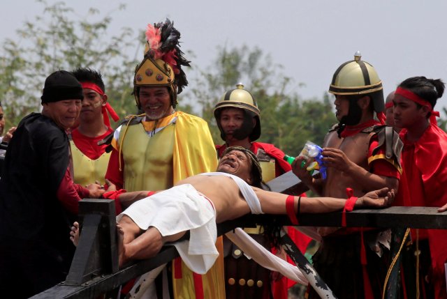 Ruben Enaje, 58, who is portraying Jesus Christ for the 32nd time, grimaces in pain as he is nailed on a wooden cross during a Good Friday crucifixion re-enactment in Cutud village, Pampanga province, north of Manila, Philippines March 30, 2018. REUTERS/Romeo Ranoco