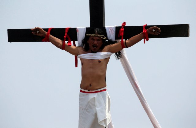 Ruben Enaje, 58, who is portraying Jesus Christ for the 32nd time, grimaces in pain after being nailed on a wooden cross during a Good Friday crucifixion re-enactment in Cutud village, Pampanga province, north of Manila, Philippines March 30, 2018. REUTERS/Romeo Ranoco