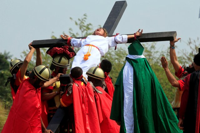 Mary Jane Sazon, 39, grimaces in pain after she was nailed on a wooden cross for the 7th time, during a Good Friday crucifixion re-enactment in Cutud village, Pampanga province, north of Manila, Philippines March 30, 2018. REUTERS/Romeo Ranoco
