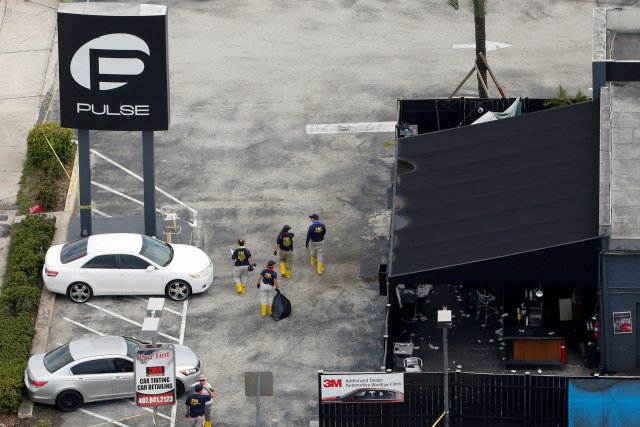 Federal Bureau of Investigation (FBI) officials walk through the parking lot of the Pulse gay night club, the site of a mass shooting days earlier, in Orlando, Florida, U.S., June 15, 2016. REUTERS/Adrees Latif/File Photo