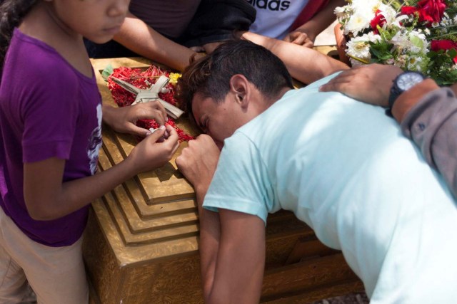 Los deudos lloran junto al ataúd de José Rivero, uno de los presos que murió durante un motín y un incendio en las celdas del Comando General de la Policía de Carabobo, durante su funeral en el cementerio de Valencia, Venezuela el 30 de marzo de 2018. REUTERS / Adriana Loureiro