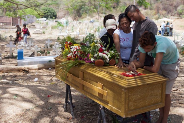 Los deudos lloran junto al ataúd de José Rivero, uno de los presos que murió durante un motín y un incendio en las celdas del Comando General de la Policía de Carabobo, durante su funeral en el cementerio de Valencia, Venezuela el 30 de marzo de 2018. REUTERS / Adriana Loureiro 