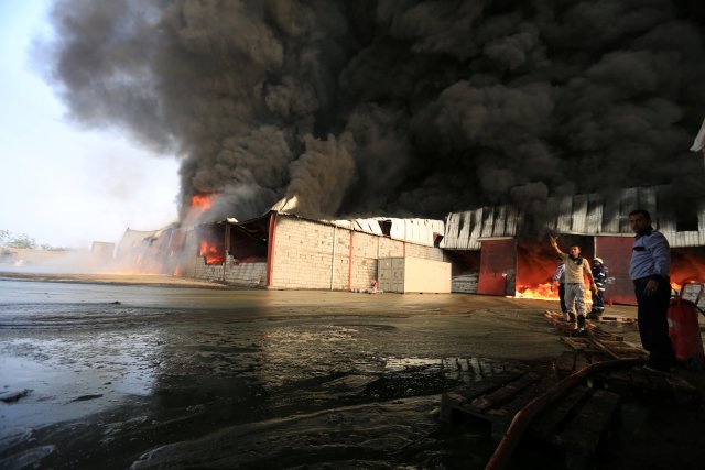 Firefighters try to extinguish a fire engulfing warehouse of the World Food Programme in Hodeida, Yemen March 31, 2018. REUTERS/Abduljabbar Zeyad
