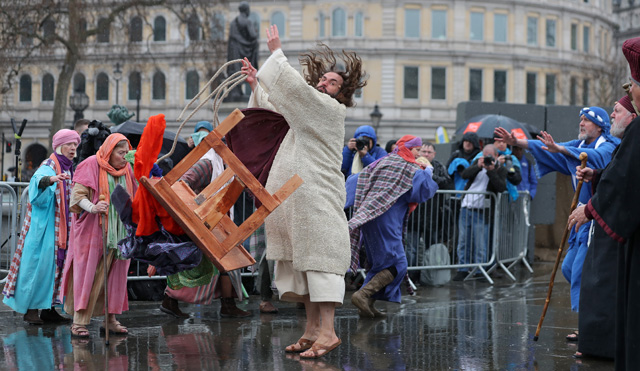 Actor James Burke-Dunsmore (C) plays the role of Jesus Christ, during a performance of Wintershall's 'The Passion of Jesus' on Good Friday in Trafalgar Square in London on March 30, 2018.  The Passion of Jesus tells the story from the Bible of Jesus's visit to Jerusalem and his crucifixion. On Good Friday 20,000 people gather to watch the Easter story in central London. One hundred Wintershall players bring their portrayal of the final days of Jesus to this iconic location in the capital. / AFP PHOTO / Daniel LEAL-OLIVAS