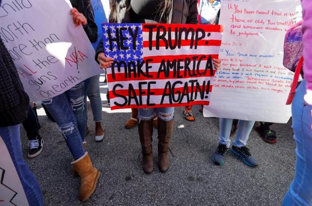 Una estudiante sostiene una pancarta en la que se lee "Hey Trump: haz a América segura otra vez", durante una protesta de estudiantes del instituto Druid Hills contra la venta de armas en Atlanta, Georgia (Estados Unidos) hoy, 14 de marzo de 2018,