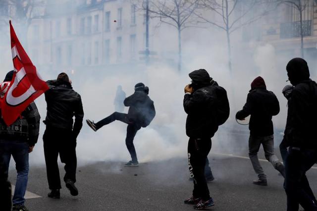 PARÍS (FRANCIA), 22/03/2018.- Manifestantes se enfrentan con la policía antidisturbios durante la huelga general de los servicios públicos y transportes en París (Francia) hoy, 22 de marzo de 2018. La huelga podría poner a prueba las reformas emprendidas por el presidente Emmanuel Macron. EFE/ Ian Langsdon